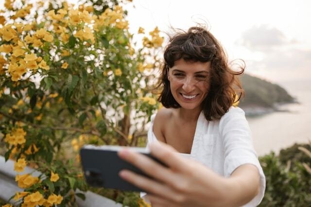 Mujer feliz mirando su celular porque habla con su pareja a distancia